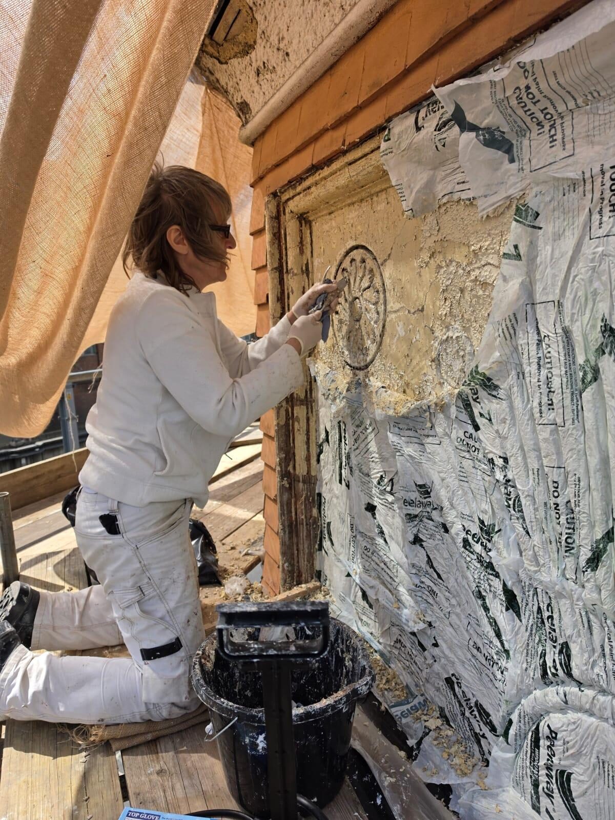 A master pargeter restoring the decorative plasterwork panels on the south turret