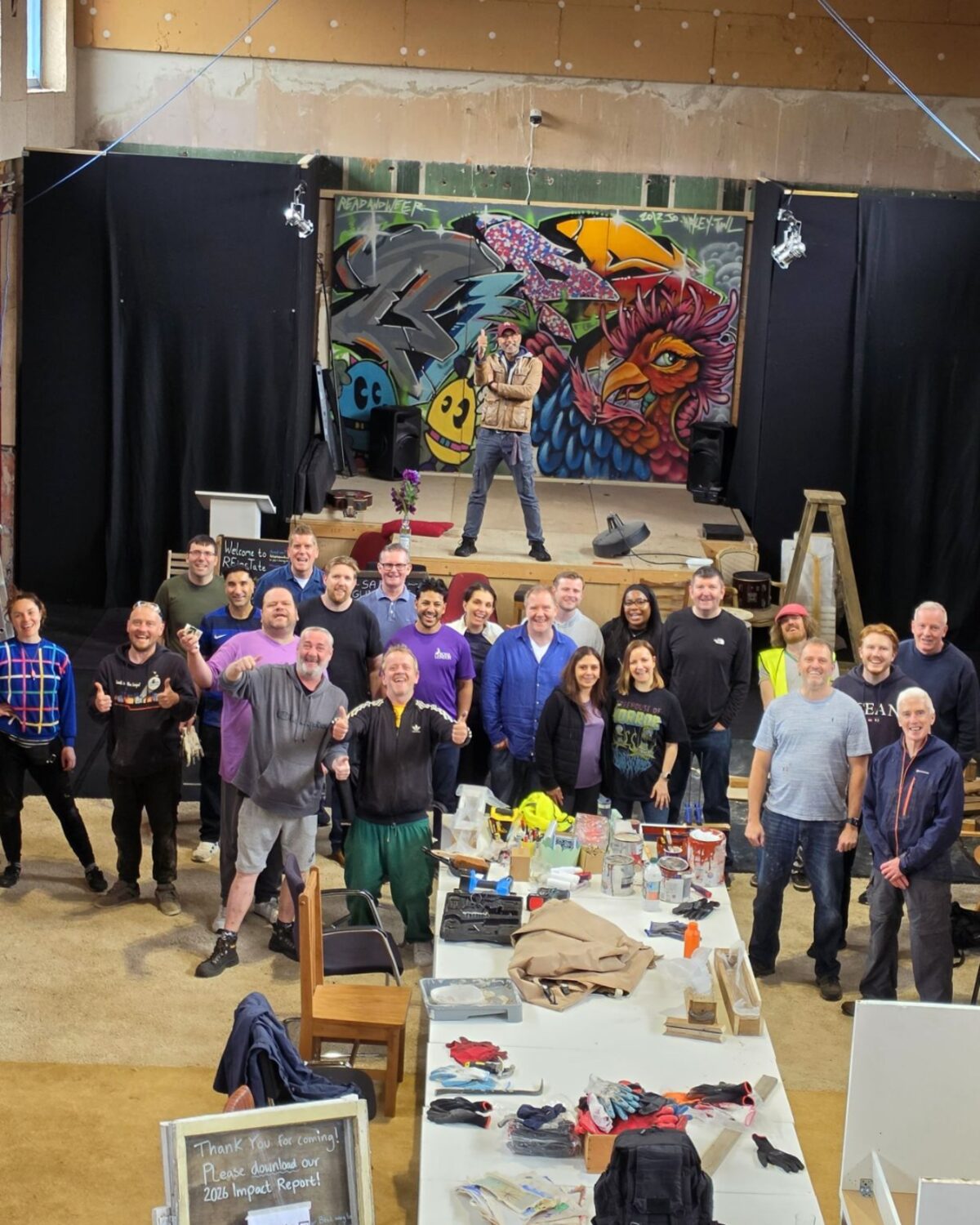A volunteer crew gathered in the Great Hall after a build day